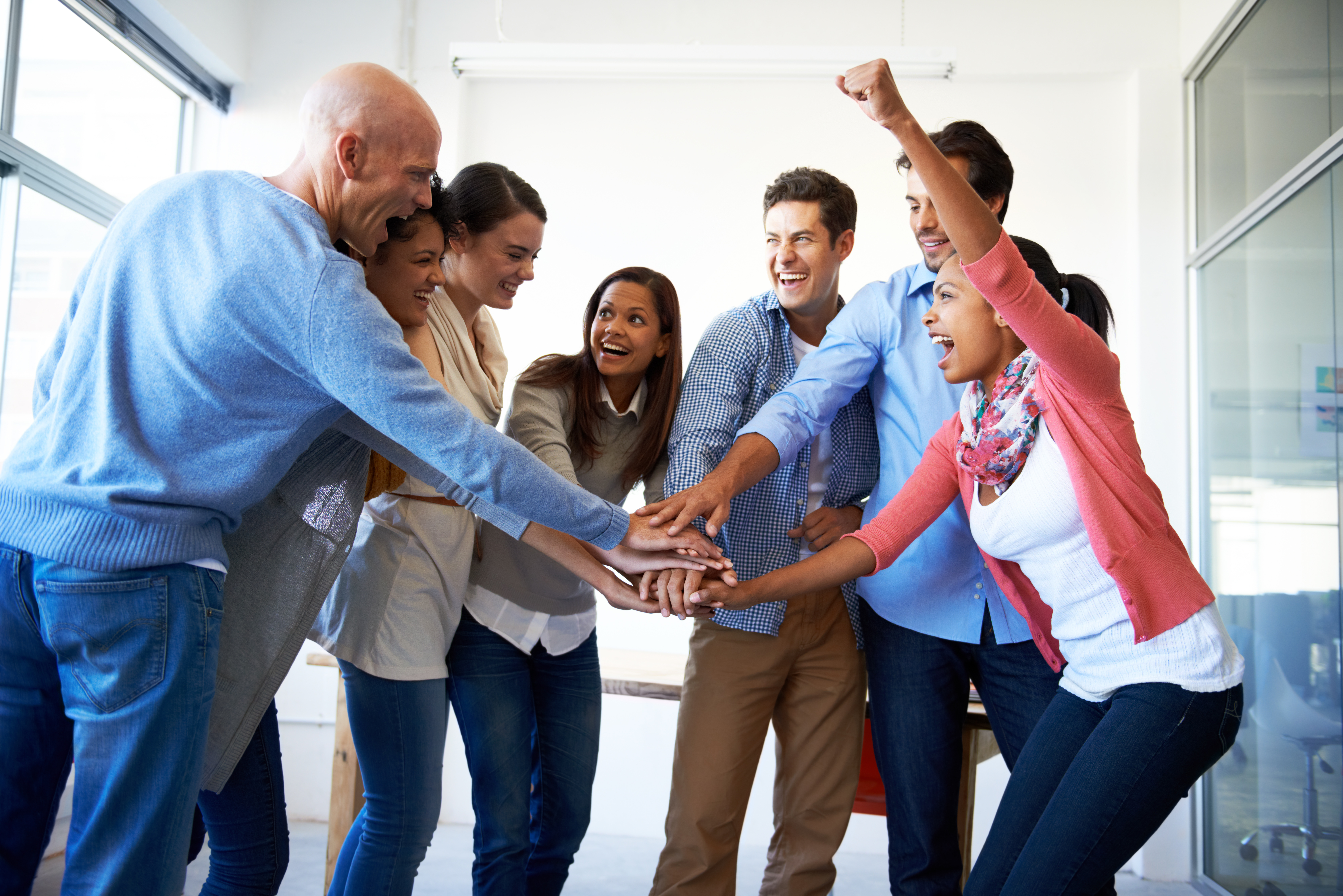Close-up of co-workers stacking their hands together