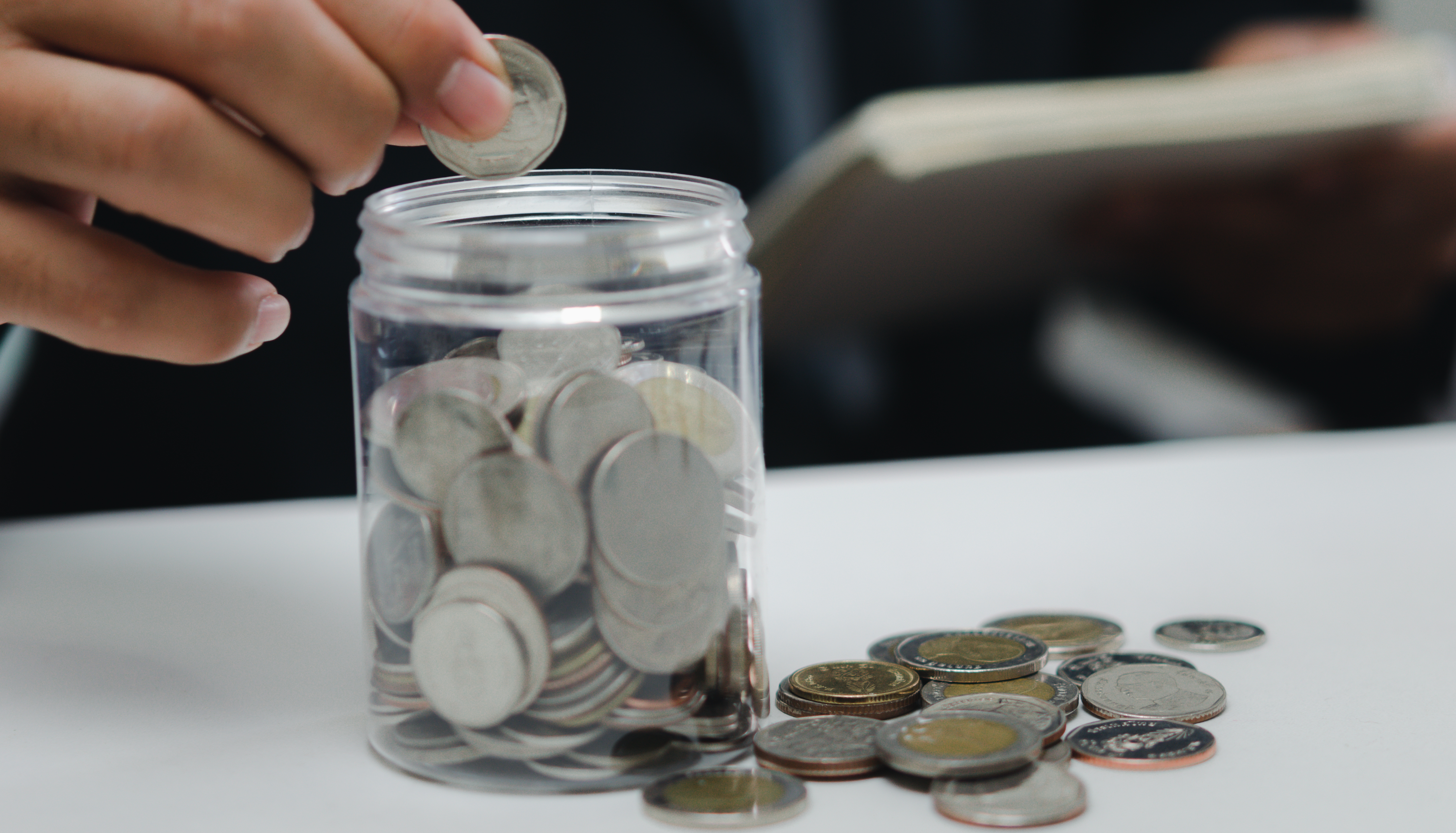 Person putting money in a savings jar